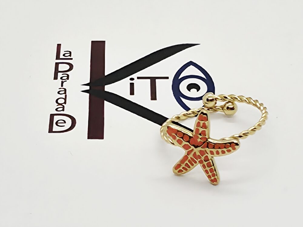 Anillo de acero dorado con una estrella de mar color naranja