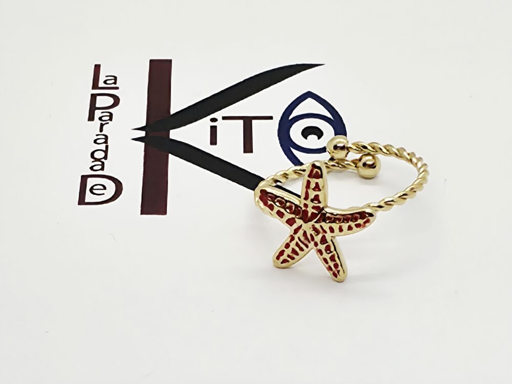 Anillo de acero dorado con una estrella de mar color rojo