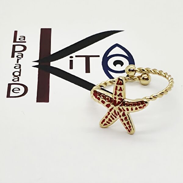 Anillo de acero dorado con una estrella de mar color rojo